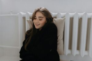donna con cuscino davanti termosifone
