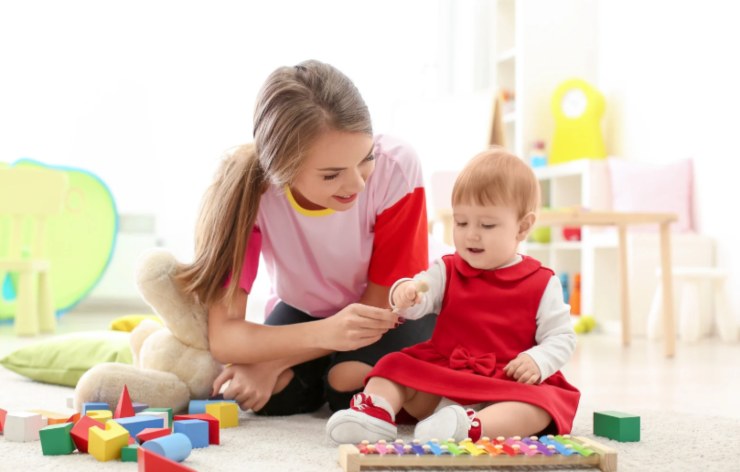 baby sitter che gioca con una bambina molto piccola