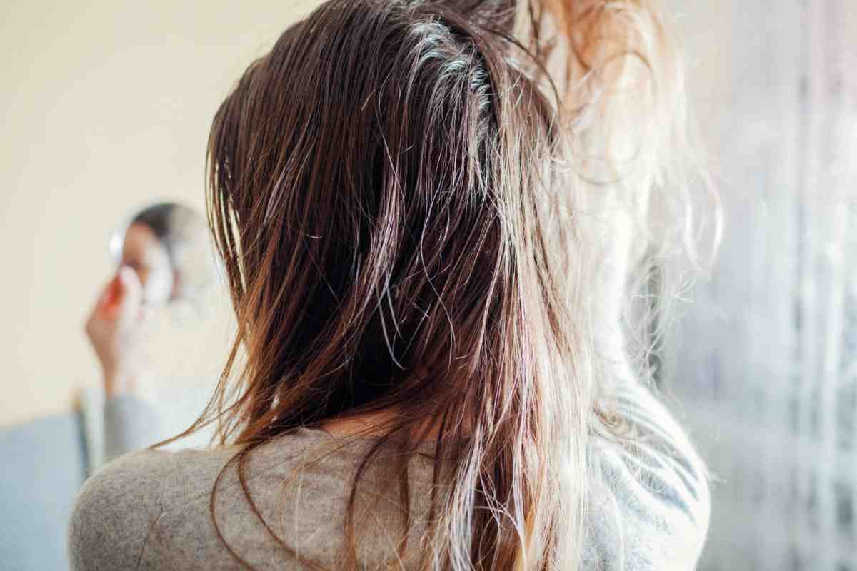 Donna di spalle che solleva ciocca di capelli