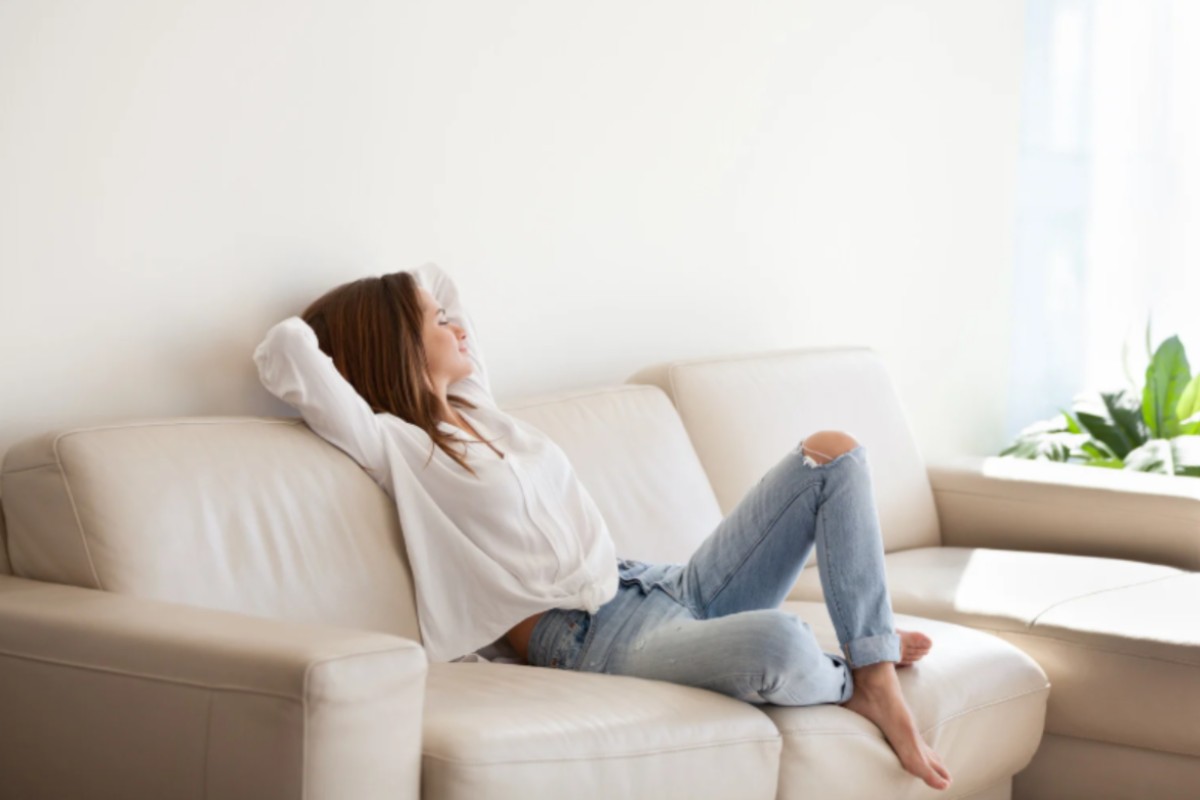 donna rilassata seduta sul divano con le braccia dietro alla testa