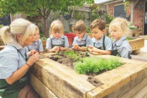 bambini e maestra intorno a un giardino